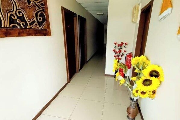 A hallway with a tiled floor, a wooden door frame, and a wall-mounted decorative panel.