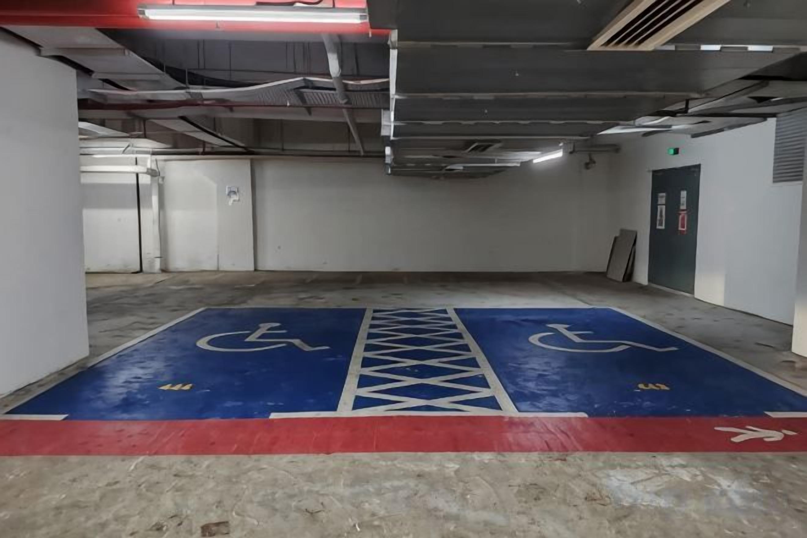 Uma garagem de estacionamento com vagas para deficientes marcadas no chão.