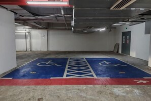 A parking garage with handicap parking spaces marked on the floor. - Pavillion Bukit Jalil 【Walk 2 mins】Stylish Lily Studio 2-4 Pax (Kuala Lumpur)