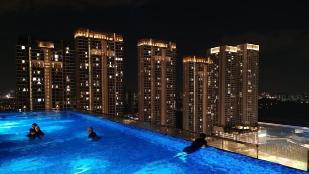 A nighttime swimming pool with illuminated buildings in the background. - Pavillion Bukit Jalil 【Walk 2 mins】Stylish Lily Studio 2-4 Pax (Kuala Lumpur)