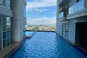 Une piscine intérieure offrant une vue sur le paysage urbain.