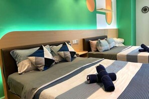 Une chambre d’hôtel avec deux lits, chacun doté d’une tête de lit, d’une table de chevet et d’un luminaire fixé au mur.