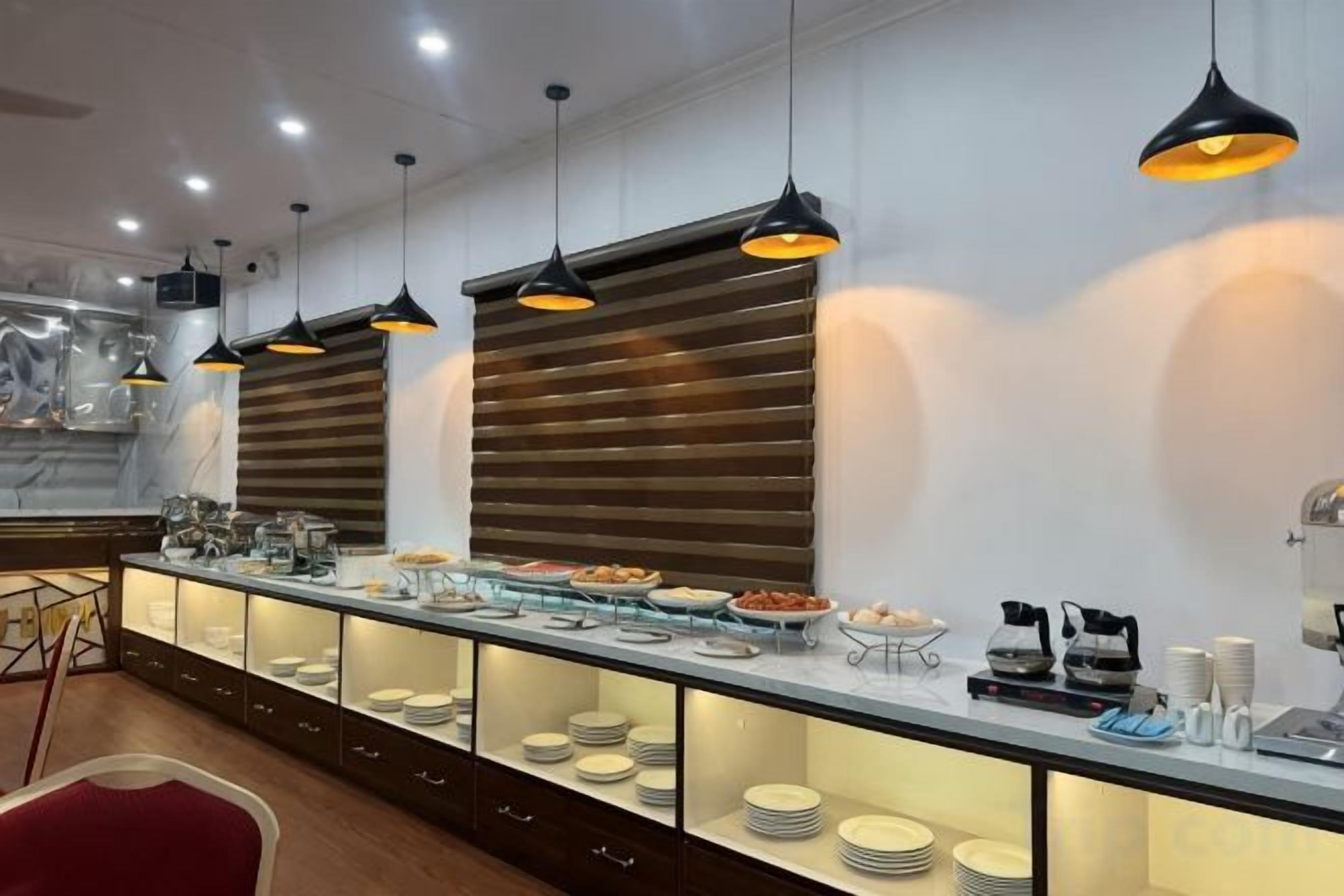 A buffet setup with multiple serving stations, overhead lighting, and a marble countertop.