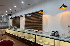 Un buffet avec plusieurs points de service, un éclairage suspendu et un comptoir en marbre.