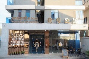 A hotel with a modern facade, a prominent entrance, and a visible outdoor seating area. - Ark House (Phnom Penh)