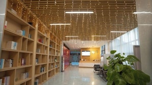 A spacious library with wooden bookshelves and a reception area. - Ark House (Phnom Penh)