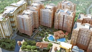 Un complejo residencial de edificios altos con varias torres de apartamentos, una piscina y un pequeño parque.