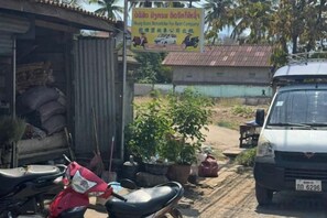 A vehicle parked in front of a building with a signboard. - Lao Hmong Hotel（Luang Prabang Old Town Center Store near JC Supermarket) (Luang Prabang)