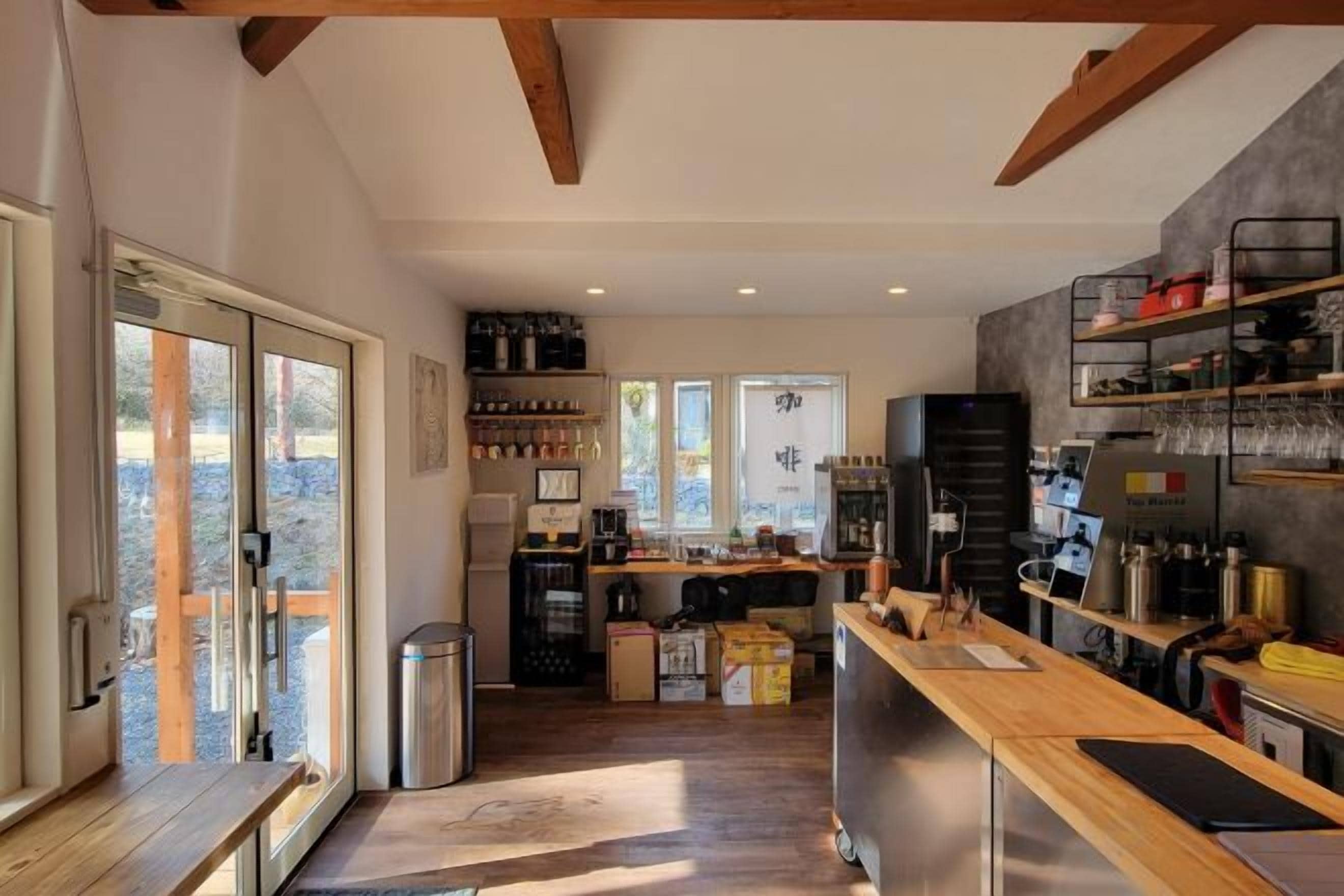 A kitchen with a wooden countertop, a refrigerator, and a coffee machine.