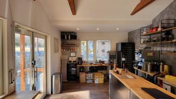 A kitchen with a wooden countertop, a refrigerator, and a coffee machine.