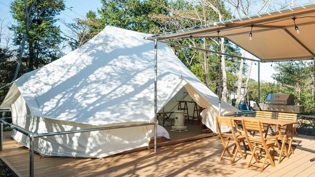 A large tent with a wooden deck and a barbecue grill. - K's Camp Izu Kogen (Ito)