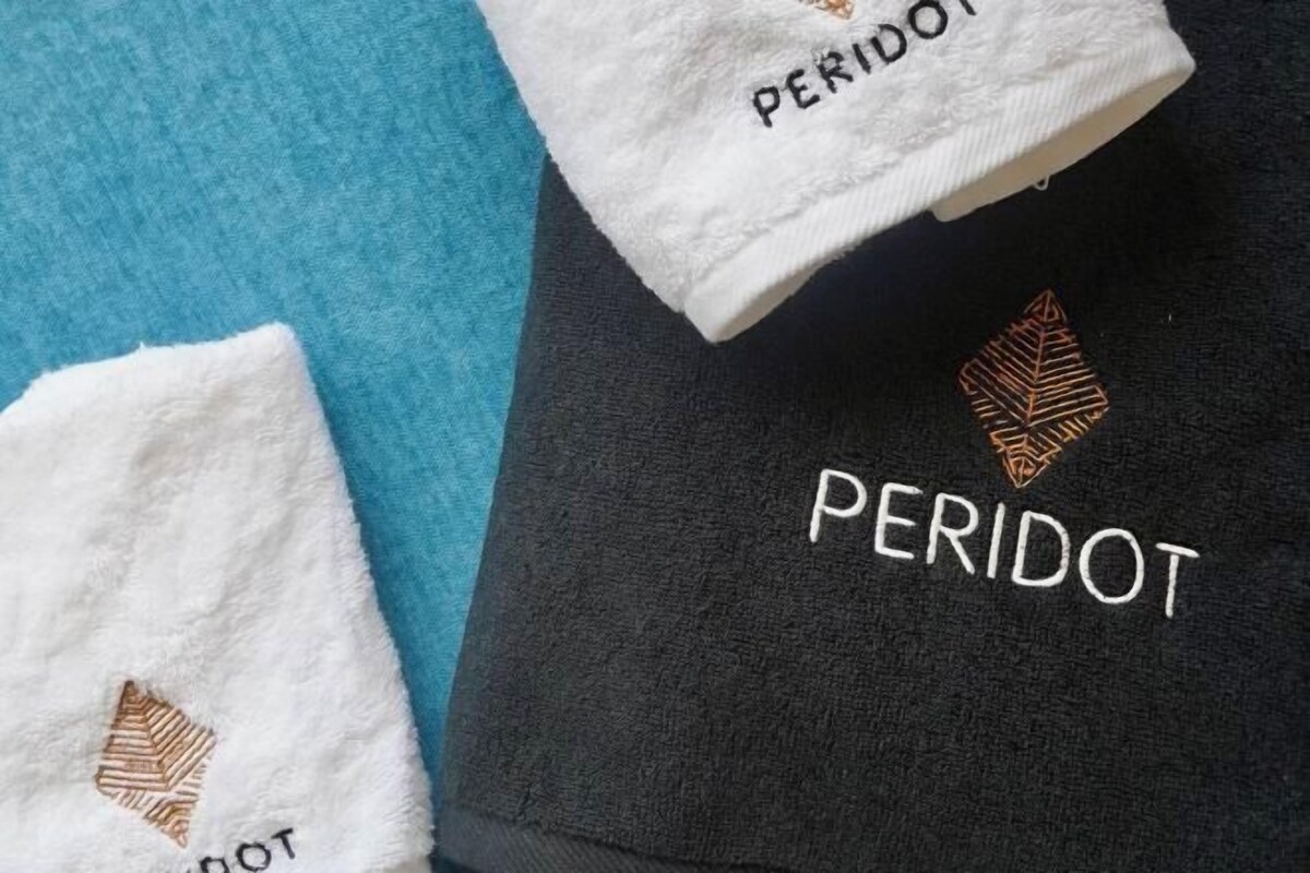 Tres toallas con el bordado 'PERIDOT'.