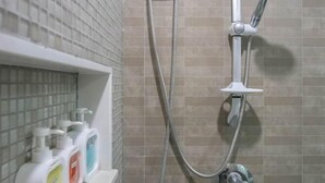 A shower with a handheld showerhead, a hose, and a wall-mounted control valve. - Roxpresso Nimman 15 (Chiang Mai)