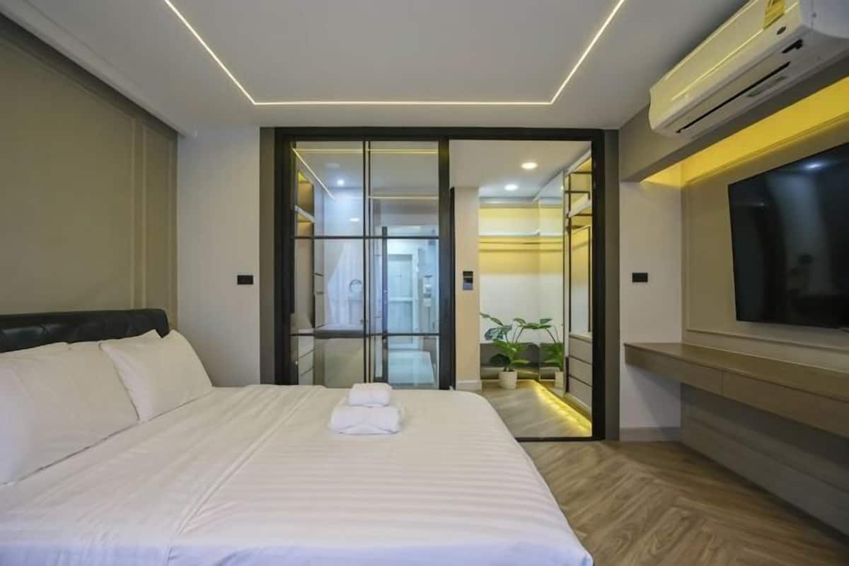 Une chambre d’hôtel équipée d’un lit, d’une télévision, d’une porte coulissante et d’un appareil de climatisation.