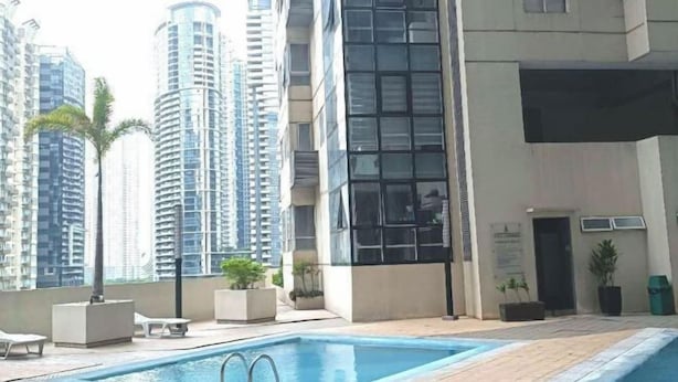 A rooftop pool area with lounge chairs and potted plants, surrounded by high-rise buildings. - Thompson Suites High Street (Fort Victoria) (Taguig)