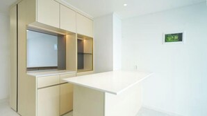 A modern kitchen with built-in cabinets and a white countertop. - Busan Ocean Stay (Busan)