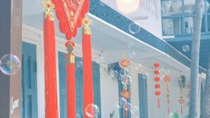 Un edificio con elementi architettonici tradizionali cinesi, tra cui decorazioni rosse e dorate e una combinazione di colori blu e bianchi.