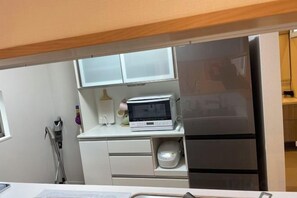 A compact kitchen with a microwave, oven, and a sink. - qinglang (Osaka)