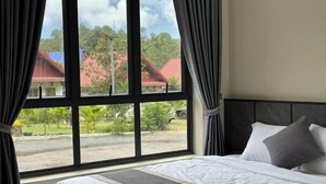 Une chambre avec une grande fenêtre, un lit et des rideaux.