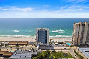 A high-rise hotel with a pool and beach view, adjacent to a beach with a parking lot and a road. - Beachfront Stay w/ Resort Amenities & Gulf Views Sterling Breezing #506 (Panama City Beach)