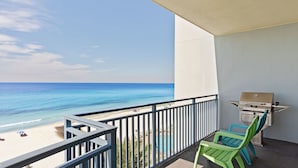 A balcony with a view of the beach and ocean, a grill, and two green chairs. - Beachfront Stay w/ Resort Amenities & Gulf Views Sterling Breezing #506 (Panama City Beach)
