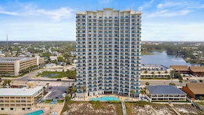 A high-rise hotel with multiple floors, a swimming pool, and a view of a lake. - Beachfront Stay w/ Resort Amenities & Gulf Views Sterling Breezing #506 (Panama City Beach)