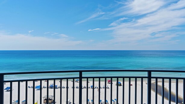 A beach view from a balcony with a railing, clear sky, and calm sea. - Sterling Breeze #604 Beachfront Condo w/ Balcony, Pool, Hot Tub & Pier Park (Panama City Beach)
