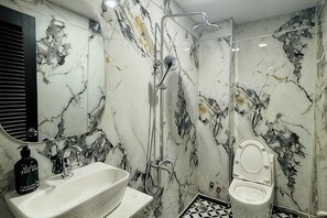 A bathroom with a sink, mirror, toilet, and shower. - Phú Gia Luxury (Ho Chi Minh City)