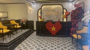 En hotellreception med en hjärtformad dekoration, ett receptionsområde med sittplatser och ett mönstrat golv.