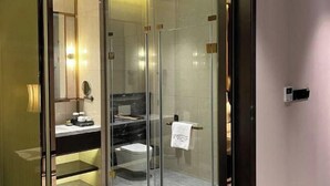 Un bagno moderno con doccia vetrata, un lavabo con piano in marmo e un portasciugamani.