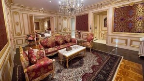 Una camera lussuosa con arredi elaborati, un lampadario e un grande tappeto decorato.