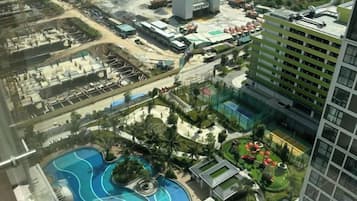 Un hotel de gran altura con piscina, jardín en la azotea y aparcamiento.