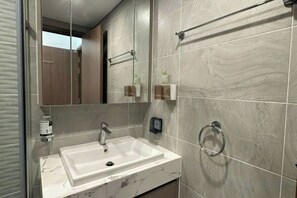 A bathroom with a white sink, a mirror, and a towel rack. - Ember Housing - Vinhomes Smart City Luxury Apartment Ha Noi (Hanoi)