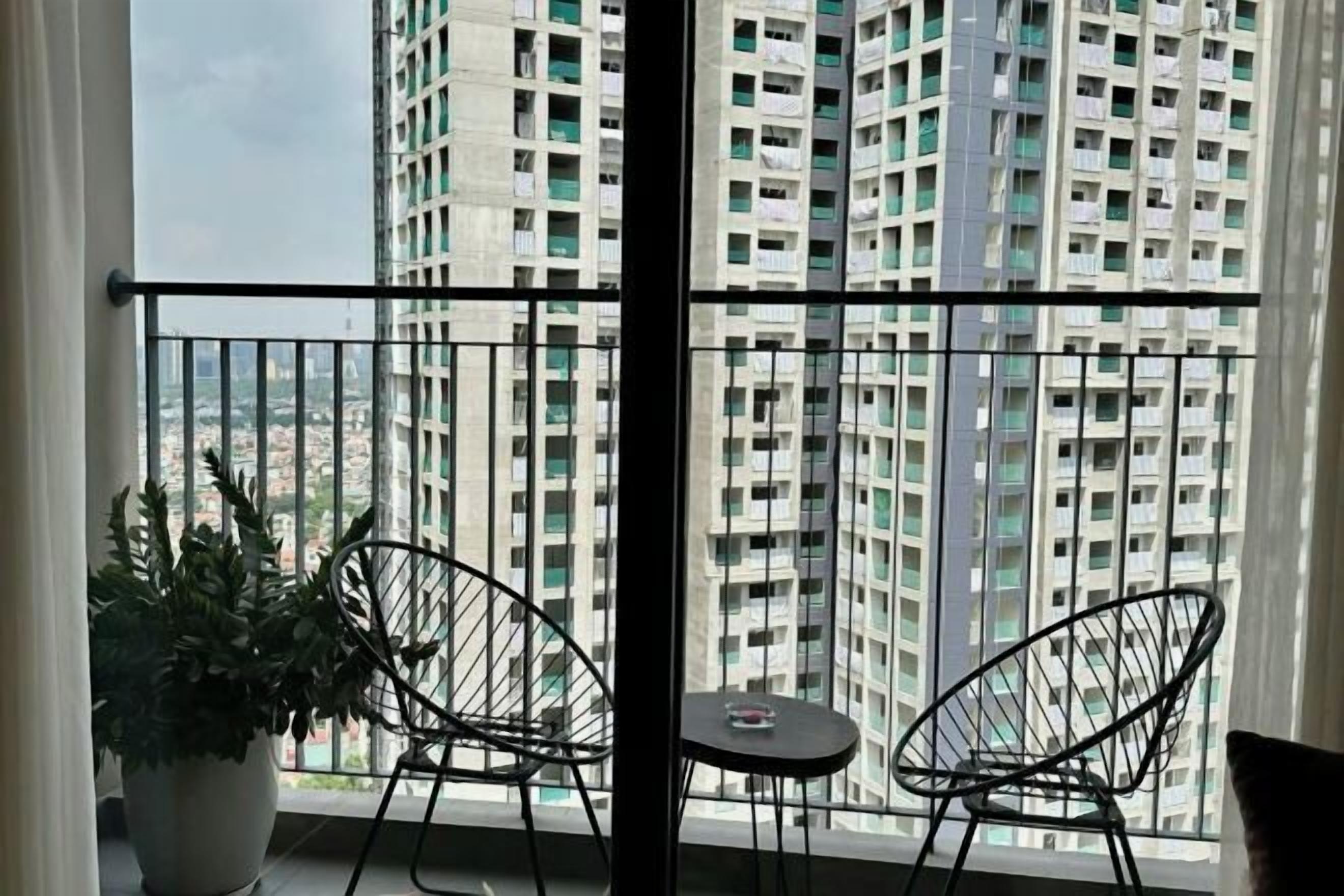 A balcony with two chairs, a small table, and a potted plant.