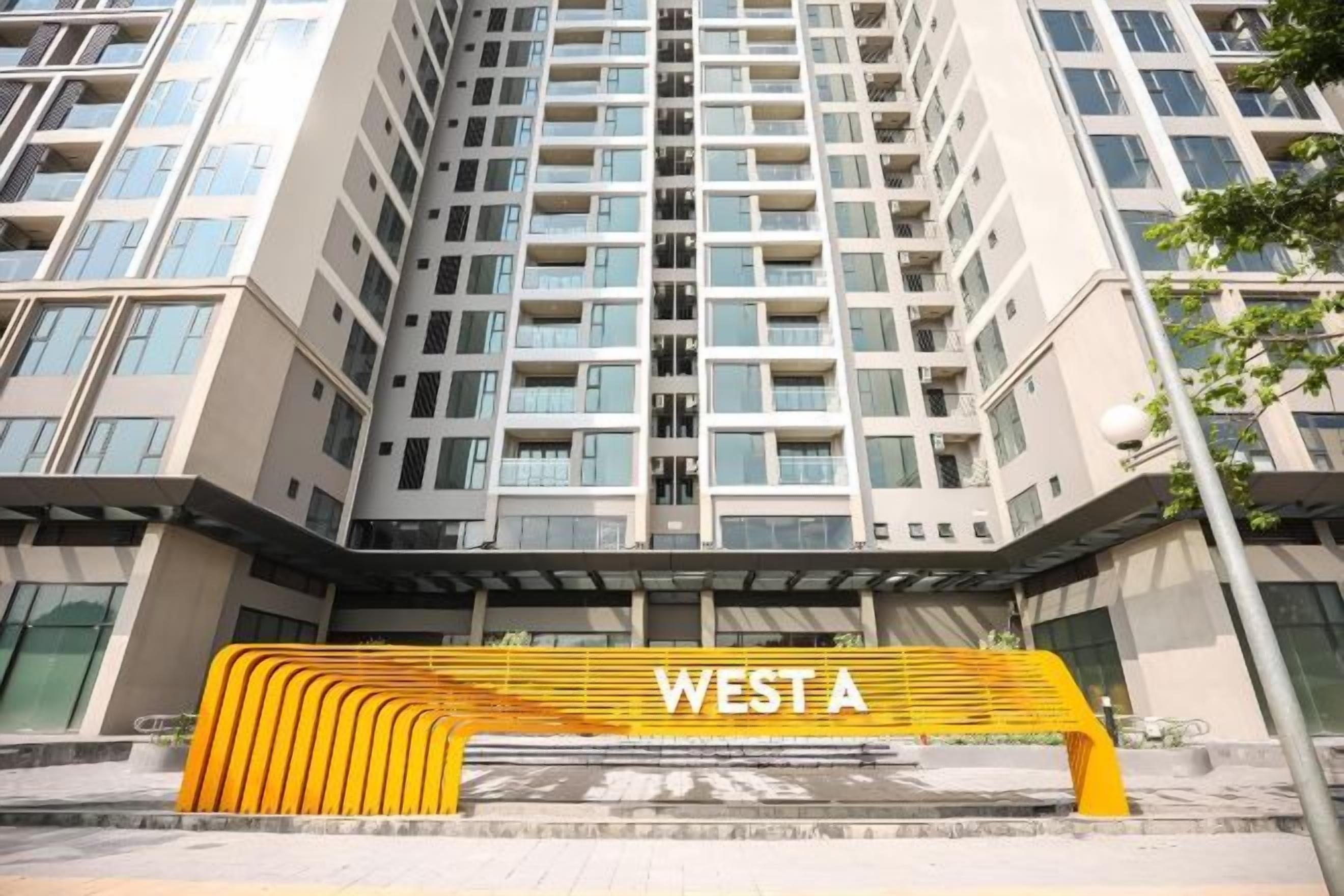 Un immeuble de grande hauteur, dont l’entrée est marquée par un grand panneau indiquant « WEST A ».