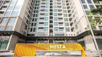 Un immeuble de grande hauteur, dont l’entrée est marquée par un grand panneau indiquant « WEST A ».