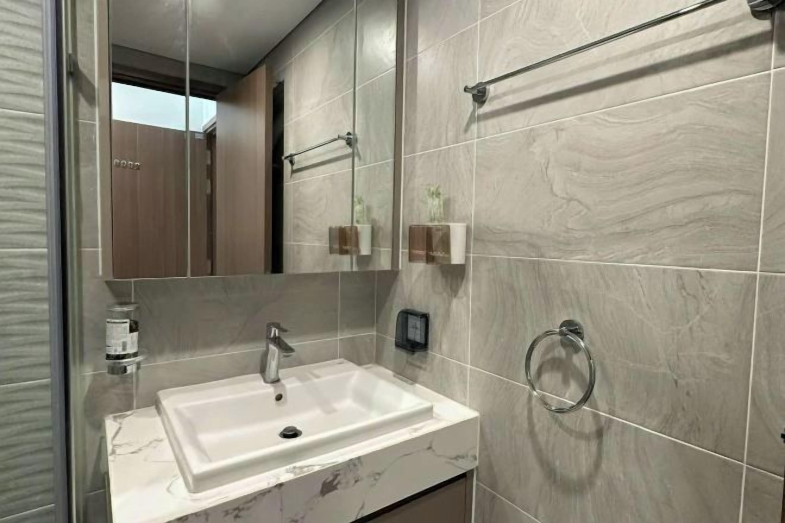 Une salle de bain moderne avec un lavabo rectangulaire, un miroir et un porte-serviettes.