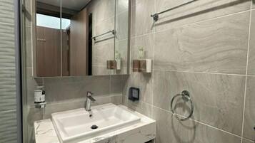 Une salle de bain moderne avec un lavabo rectangulaire, un miroir et un porte-serviettes.