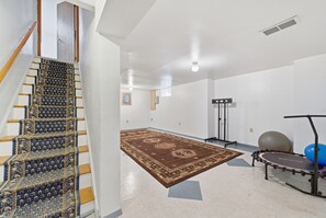 Une pièce spacieuse avec un tapis à motifs, une barre de traction et du matériel d’exercice.