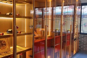 A hotel elevator with glass doors, a red carpet, and a view of the outside. - TDH HOTEL (Ikeja)