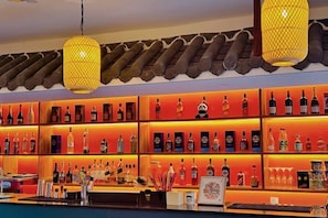 Eine Bar mit Regalen voller Flaschen und einer Theke.