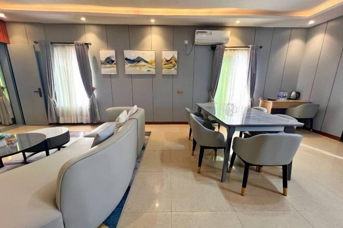 A modern dining area with a table and chairs, a sofa, and artwork on the walls.