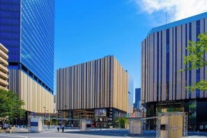 A modern urban street with tall buildings, a clear sky, and a pedestrian crossing. - Ikebukuro Central Hotel (Tokyo)