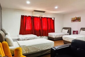 A hotel room with two beds, a sofa, a chair, and a small table. - Hotel Traveler's Majestic Retreat, Located in the Heart of Melaka (Melaka)