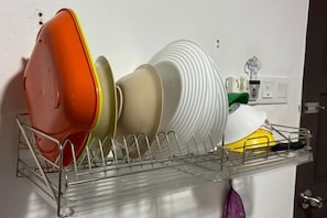 A dish rack with various plates and a yellow bowl. - Hotel Traveler's Majestic Retreat (HOTEL TMR), Located in the Heart of Melaka (Melaka)