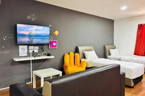 A hotel room with a bed, a sofa, a TV, and a small table. - Hotel Traveler's Majestic Retreat, Located in the Heart of Melaka (Melaka)