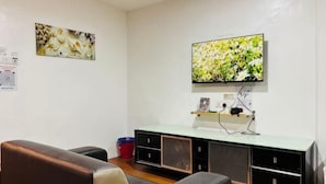A room with a television mounted on the wall, a sofa, and a cabinet with drawers. - Hotel Traveler's Majestic Retreat, Located in the Heart of Melaka (Melaka)
