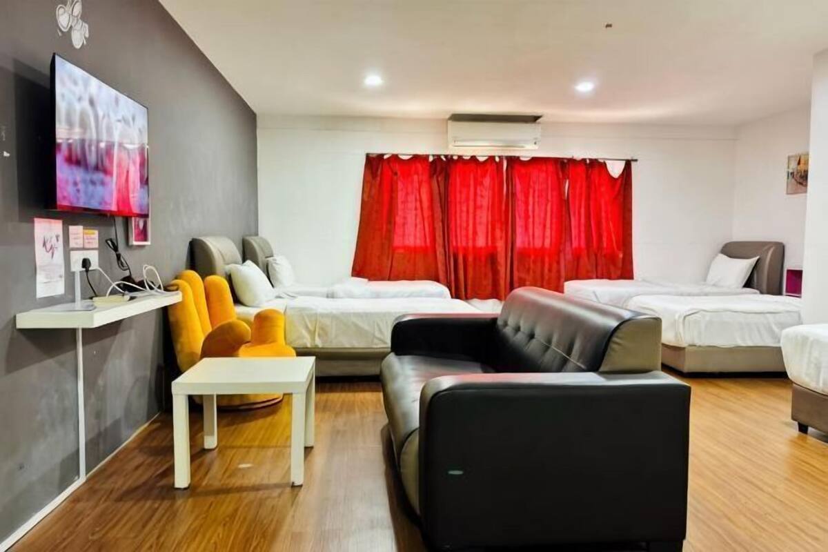 A hotel room with a bed, a sofa, a TV, and a desk.