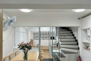 A modern interior with a dining area, staircase, and kitchen. - Tonbon Home - Japanese style living (Ho Chi Minh City)