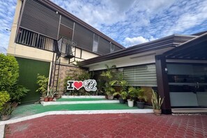 A modern building with a balcony, a green awning, and a sign that says "I ♥ LA". - Pensionne Alonso by RedDoorz (General Santos)